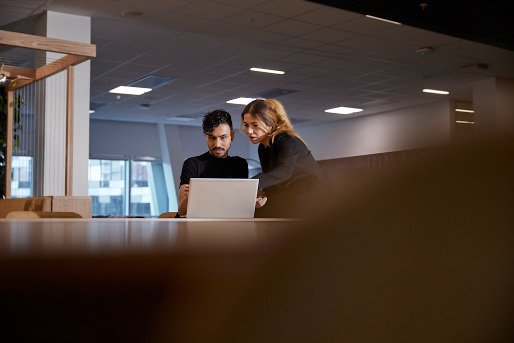 Kvinna och man på kontor med laptop