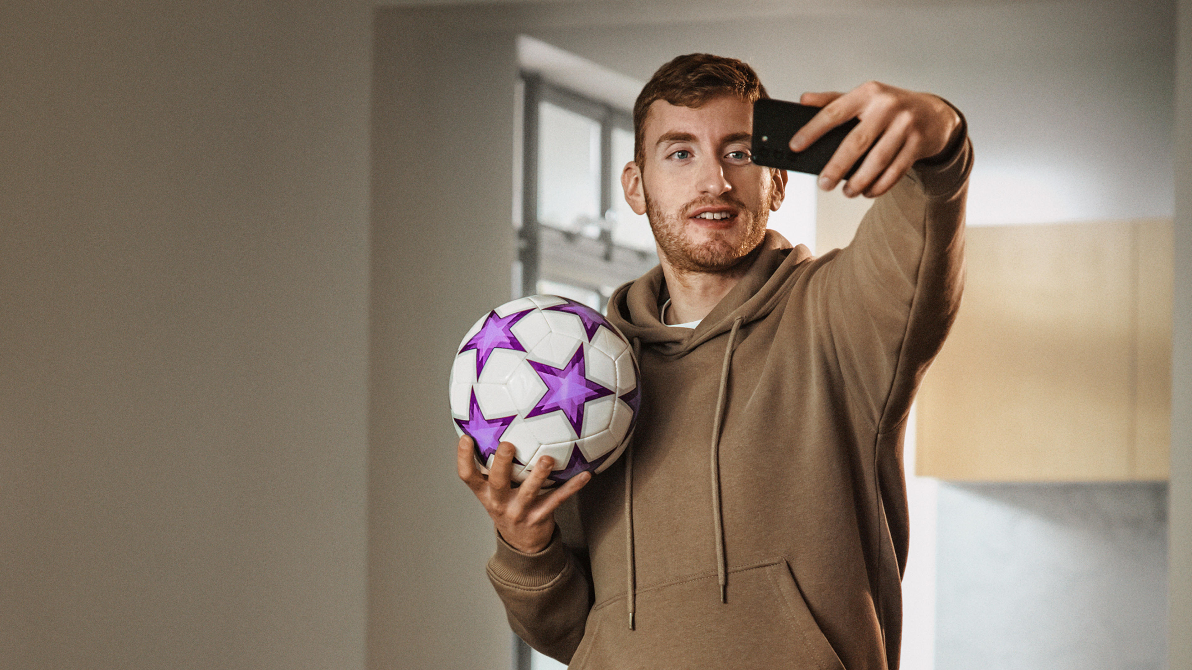 Dejan Kulusevski tar en selfie poserande med en fotboll. Kulusevski följer UEFA Champions League 2023 och alla andra ligor i Telia Play.