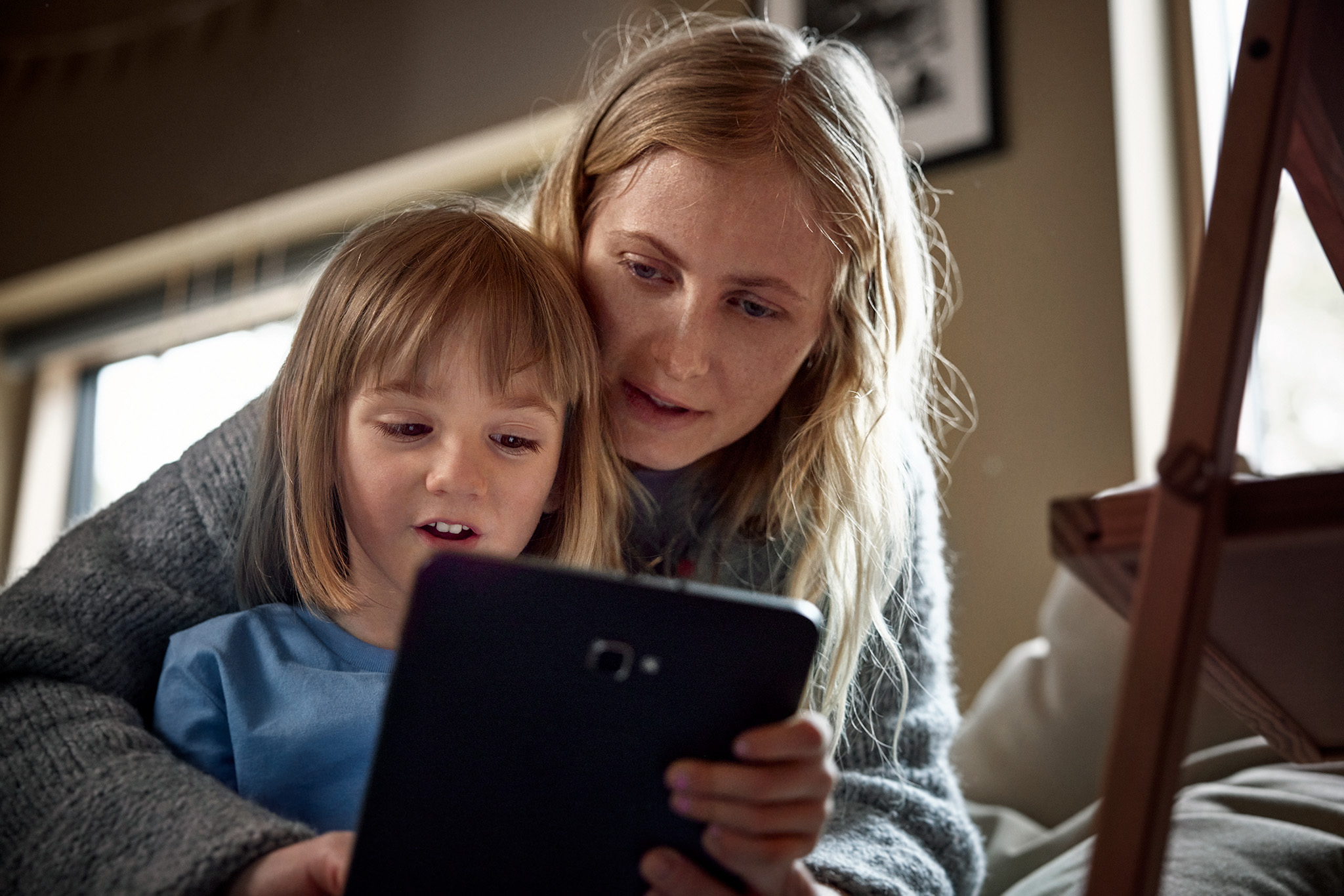 Familjemys - mamma och flicka streamar barnprogram på surfplatta.