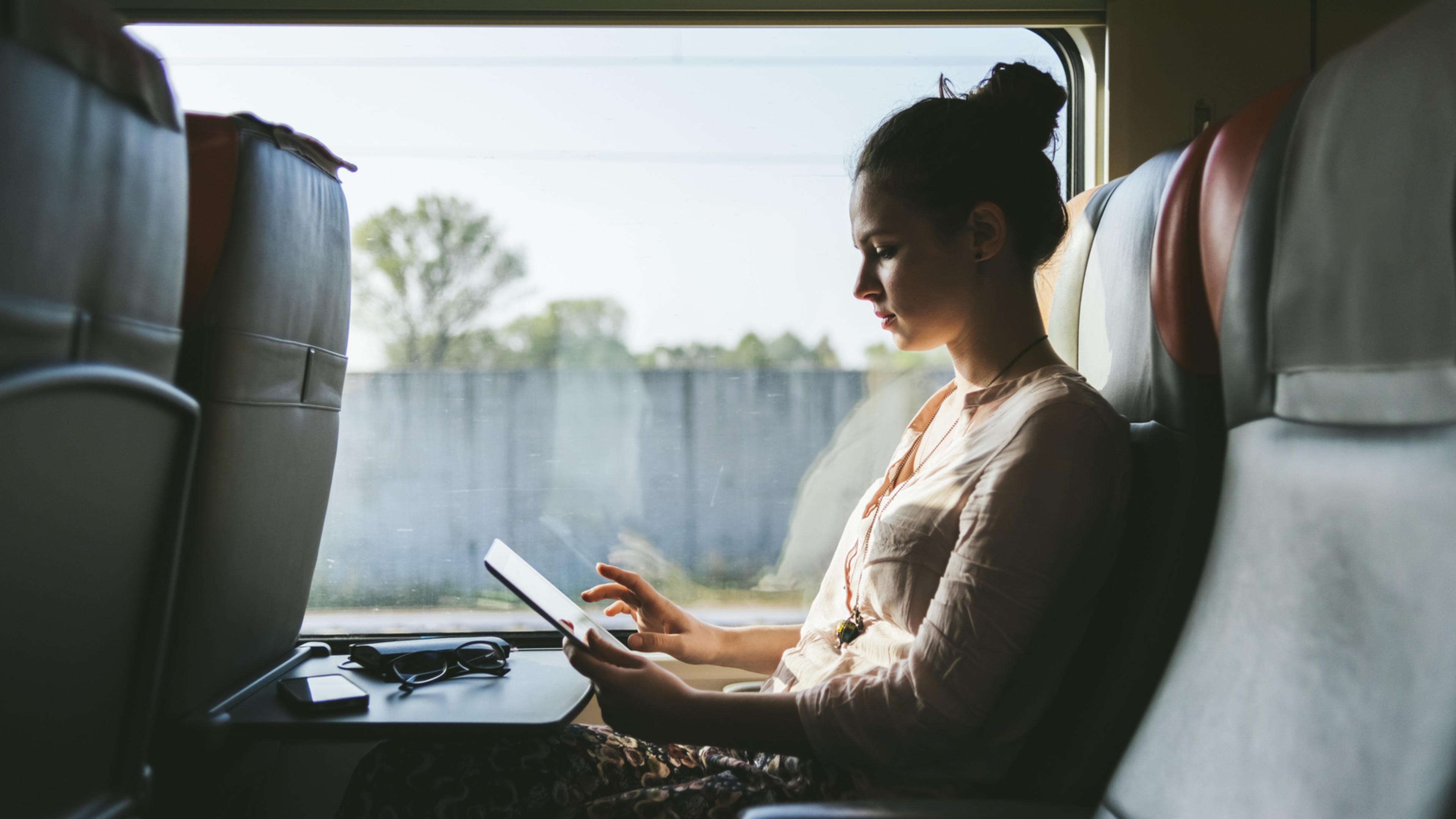 Kvinna arbetar med mobilt bredband på tåg.