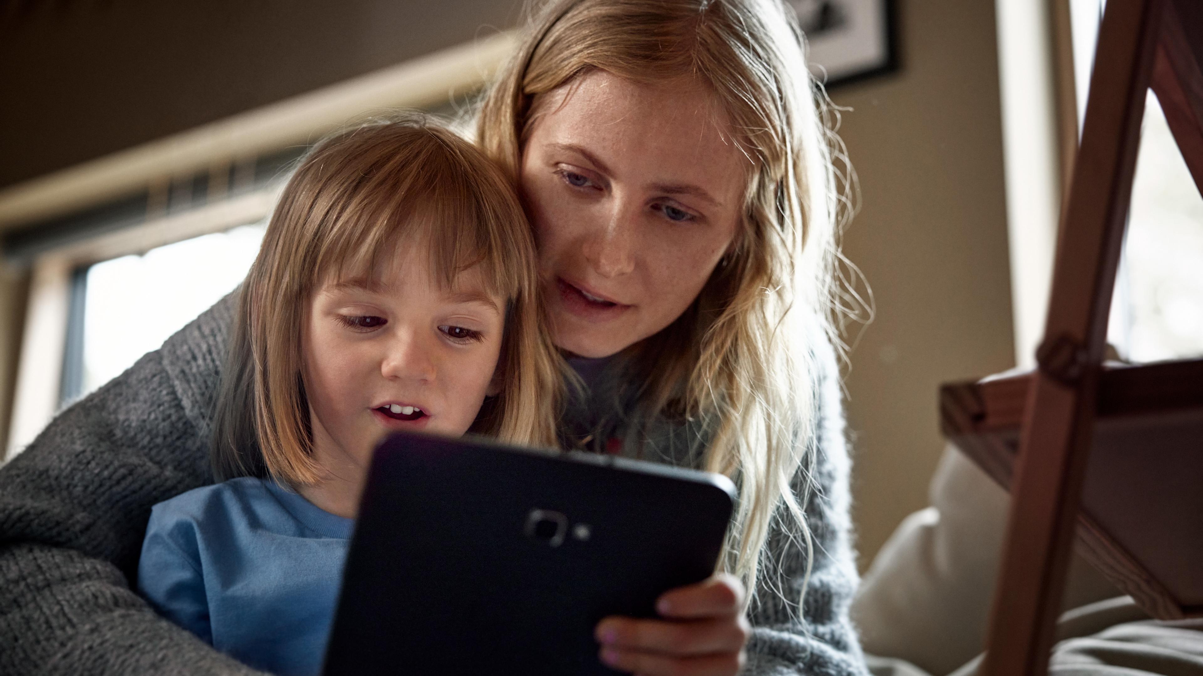 Kvinna och barn tittar på surfplatta