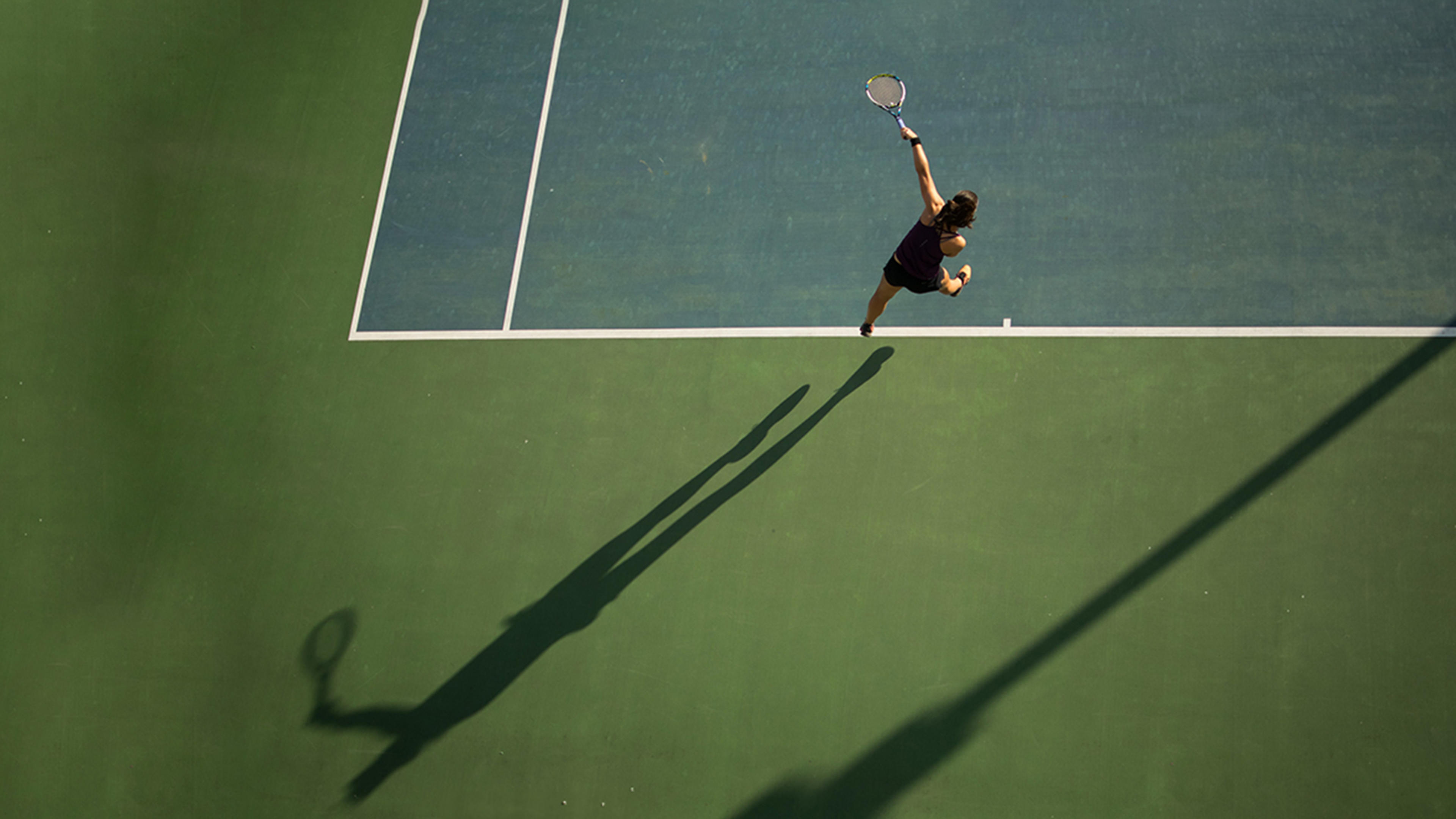 Tennis - tennisspelare på courten slår med tennisracket.
