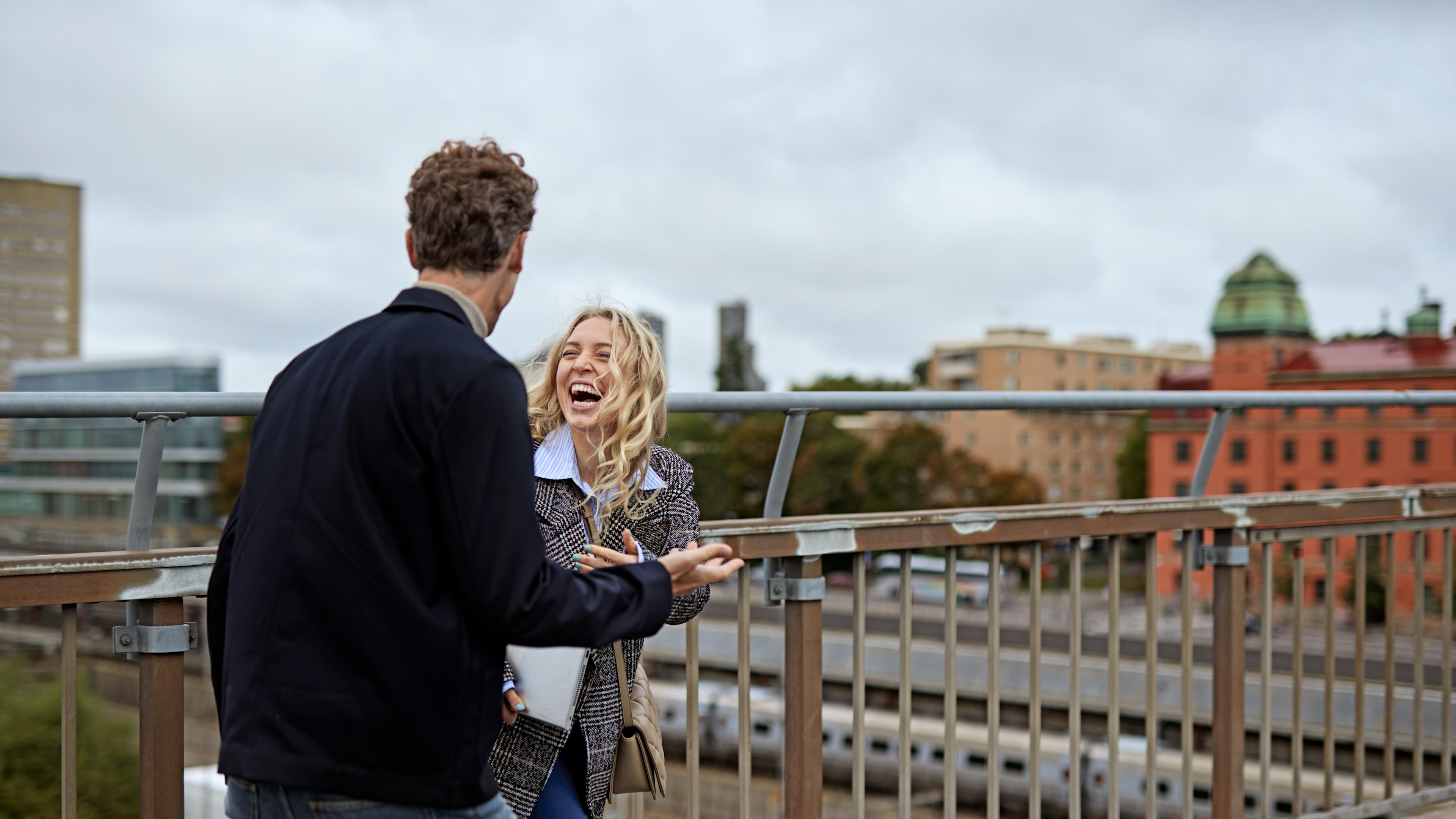 Kvinna och man pratar på takterrass i Stockholm