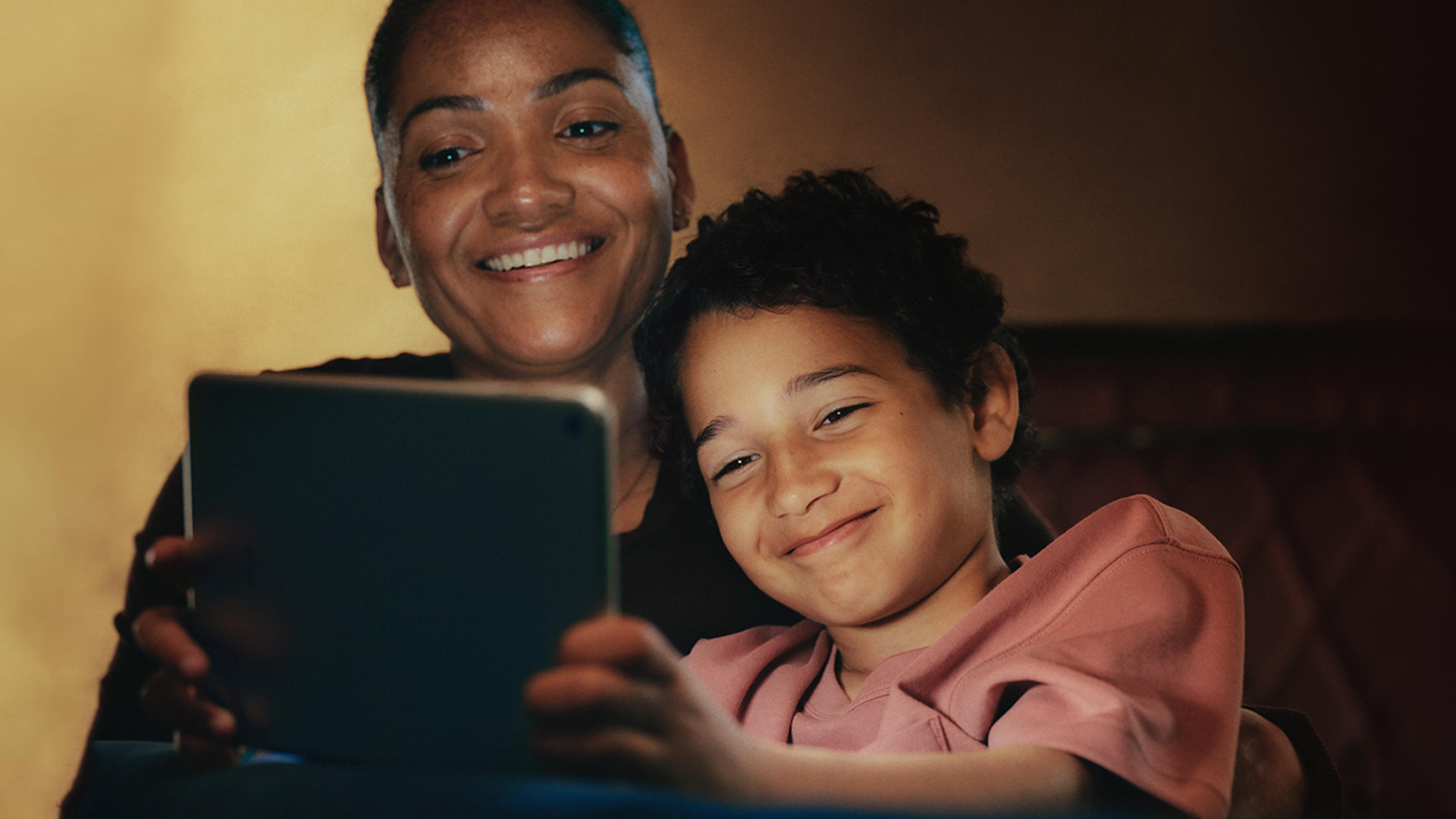 mamma och barn kollar på surfplatta