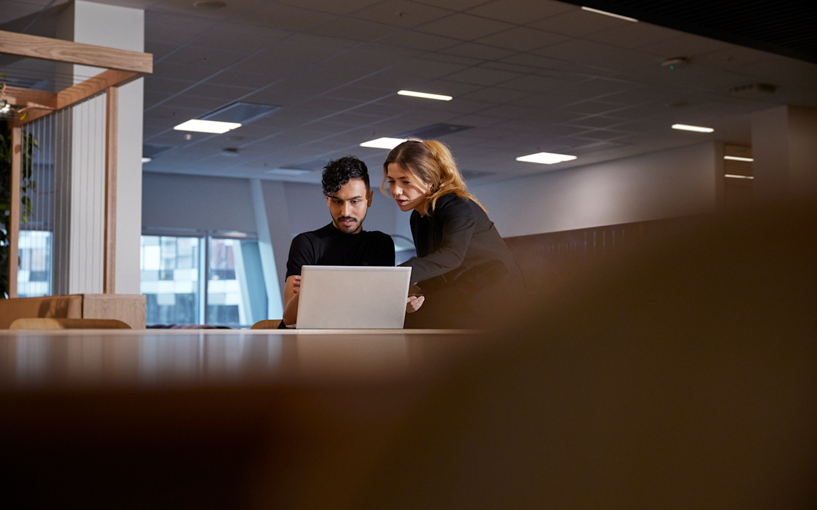 Kvinna och man på kontor med laptop