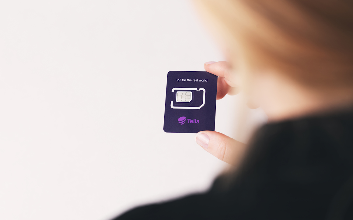 Hand som håller simkort mellan tummen och pekfingret