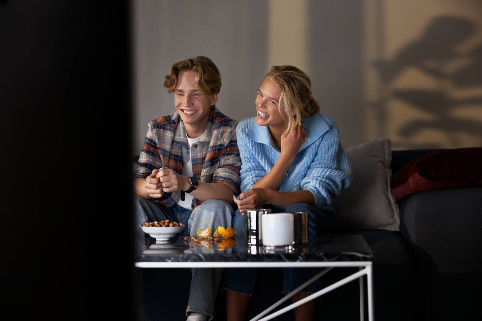 Ungt par tittar på tv och streaming från Telia Play.