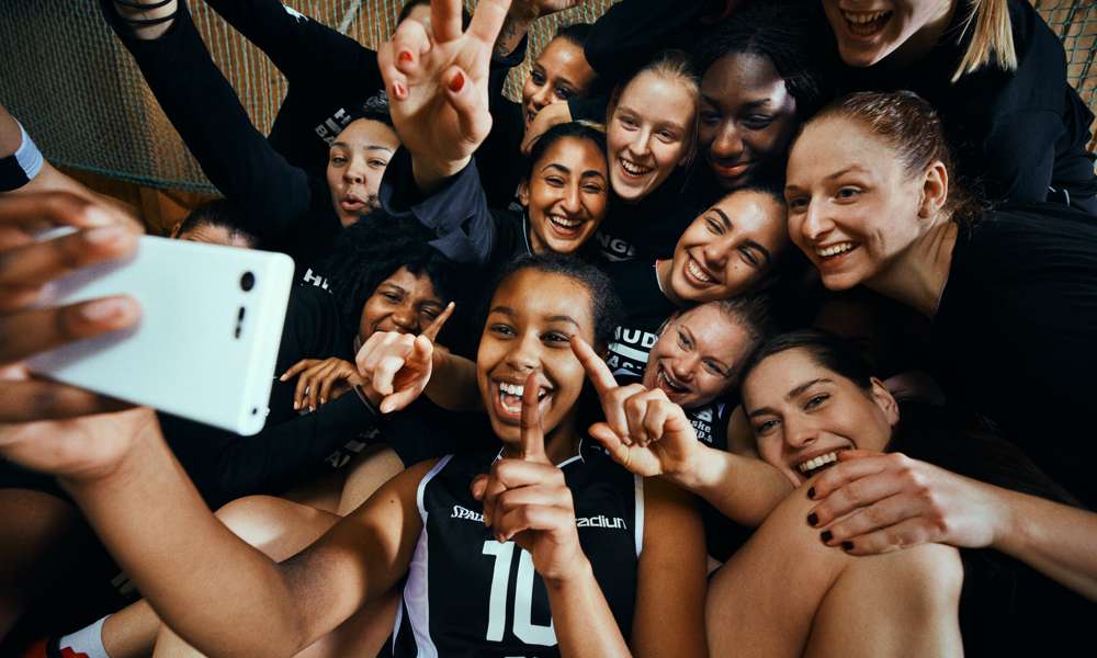 Glada baskettjejer tar en selfie tillsammans.