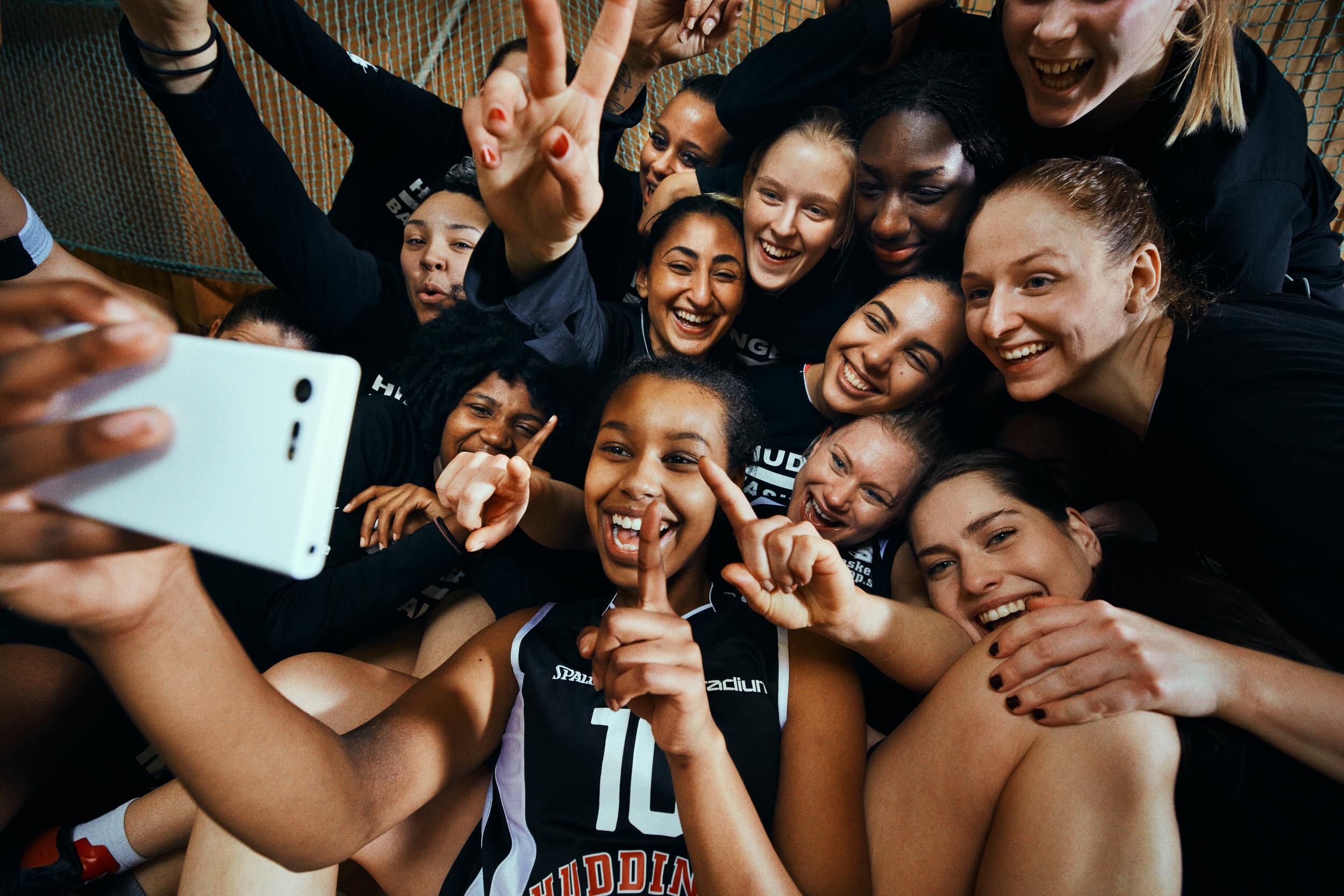 Glada baskettjejer tar en selfie tillsammans.